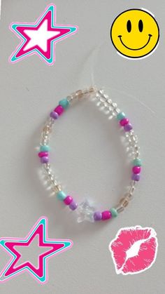 a bracelet with pink, blue and green beads on it next to a smiley face sticker