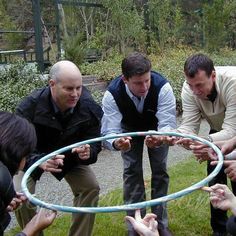 several people are gathered around a hula hoop