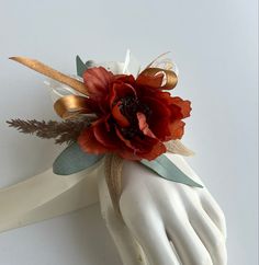 a hand with a flower on top of it next to a pair of white gloves