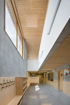 the inside of a building with wooden shelves and benches on either side of the room