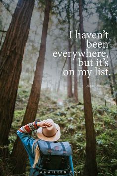 a person wearing a hat standing in the woods with their back turned to the camera