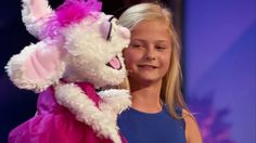 a woman in a pink dress holding a white stuffed animal with her mouth open and tongue out