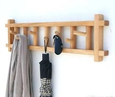 a coat rack with two umbrellas hanging from it's sides and an umbrella on the other side