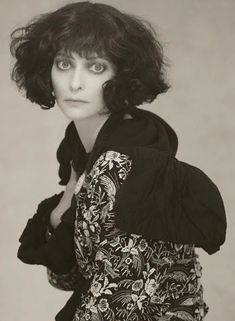 black and white photograph of a woman with short hair wearing a jacket, looking at the camera