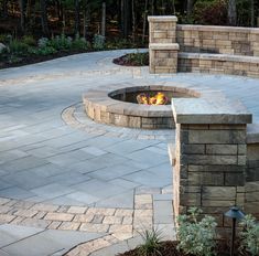 an outdoor fire pit surrounded by stone walls