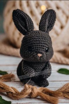 a crocheted black bunny sitting on top of a table