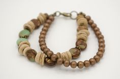 This 7-inch multi-strand beaded boho bracelet was handmade with care just for you. I used 8mm Imperial Jasper stones, and 6mm coconut wood donuts with brass embellishments on one strand, and 4mm bronze metal beads on the second strand. These two strands are made using Beadalon #19 (0.61mm) wire and are secured with a brass lobster clasp.  Bracelet shown measures 7 inches in length. Fits comfortably on a 6 inch wrist and is perfect for any occasion. Bronze Bracelet, Coconut Wood, Bronze Bracelets, Brown Bracelet, Bracelet Metal, Imperial Jasper, Wood Bracelet, Clasp Bracelet, Boho Green