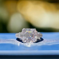 an old cut diamond ring sitting on top of a blue surface