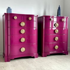 two pink chests with gold knobs and handles on each side, against a white wall