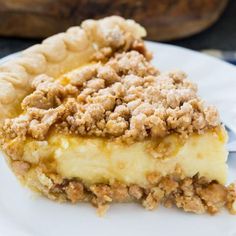 a piece of pie sitting on top of a white plate with crumb toppings