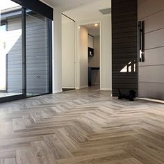 an empty room with wood flooring and sliding glass doors that lead to the outside