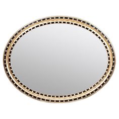 a round mirror with black and gold trimmings on the edges, in front of a white background