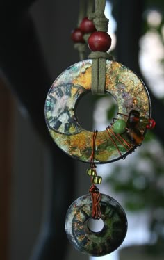 a wind chime hanging from a tree branch with beads and other things on it