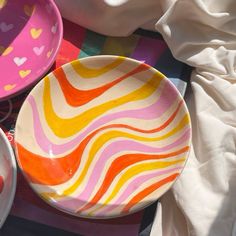 three colorful bowls sitting on top of a table next to each other with hearts painted on them