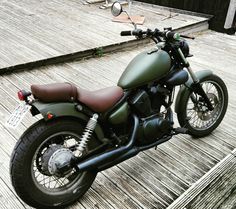 a green motorcycle parked on top of a wooden deck