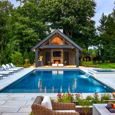 an outdoor pool with lounge chairs and fire pit