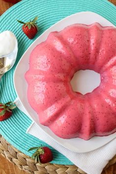 a bundt cake sitting on top of a white plate with strawberries next to it