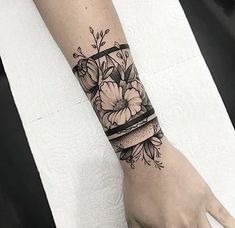 a woman's arm with flowers and a cake tattooed on the left side of her arm