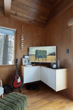 a room with wooden paneling and a guitar on the counter in front of it