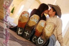 a man and woman kissing in front of shoes with words written on the soles