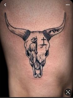 a bull skull with a cross on it's side