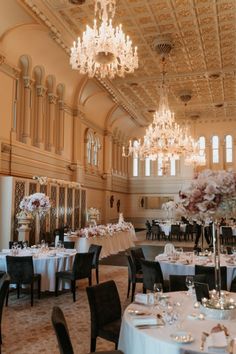 an elegant ballroom with chandeliers and tables