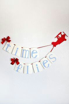 a banner that says time flies on it with red and white ribbon hanging from the side