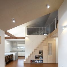 an open floor plan with stairs leading up to the kitchen and dining room area in this modern home