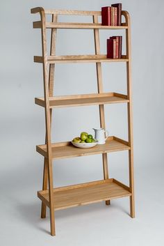 a wooden shelf with books and fruit on it