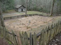 an old wooden fence in front of a small cabin