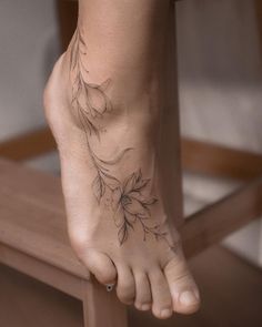 a woman's foot with a flower tattoo on her left side and the bottom part of her right foot