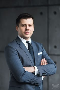 a man in a suit and tie with his arms crossed