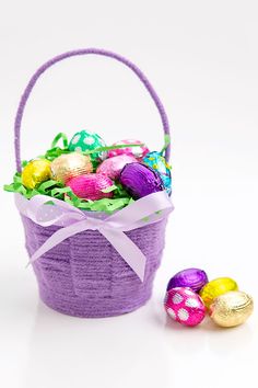 an easter basket filled with chocolate eggs next to some other colorfully colored candies