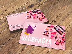 two business cards with makeup on them sitting next to each other in front of a wooden floor