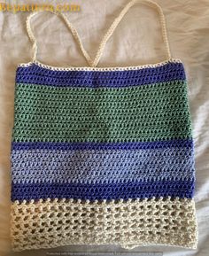 a crocheted bag sitting on top of a bed