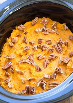 a close up of a casserole dish in a crock pot with pecans on top