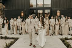 a bride and groom walking with their wedding party