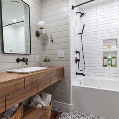 a bathroom with a sink, mirror and bathtub next to a walk in shower