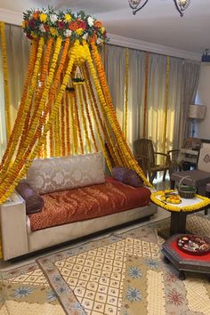 a living room filled with furniture covered in yellow and orange garlands on the ceiling