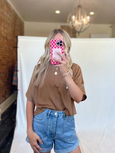 From workwear to date night this silky blouse is a no brainer! It has longer short sleeves, a middle seam and a keyhole button back. Styled with the Perfect Pair Rolled Denim Shorts and Erica Embroidered Slides. beautiful mocha/coffee color slightly cropped fit 58% polyester, 42% rayon care instructions: hand wash cold, hang dry true to size Paige is 5'6" wearing a small Brown Relaxed Fit Crew Neck Blouse, Brown Relaxed Fit Blouse For Day Out, Brown Relaxed Fit Short Sleeve Blouse, Brown Short Sleeve Blouse For Spring, Brown Relaxed Fit Blouse For Work, Brown Short Sleeve Blouse For Fall, Trendy Brown Short Sleeve Blouse, Chic Brown Short Sleeve Blouse, 2024 Wardrobe