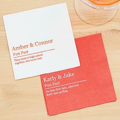 two business cards sitting on top of a table next to a bowl of oranges