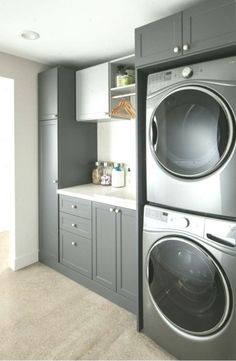 a washer and dryer in a room with gray cabinets on either side of the door