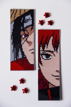 two cross stitch bookmarks with red stars next to each other on a white surface