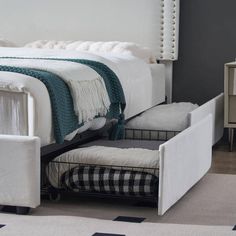 a white bed with two drawers underneath it