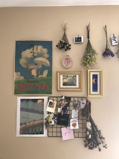 a wall with pictures, flowers and other items on it's side hanging from the wall