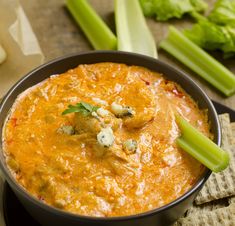 a bowl filled with dip and celery sticks