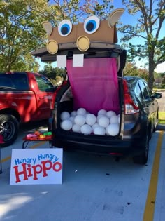 the trunk of a car with balloons in it is decorated to look like a hippo