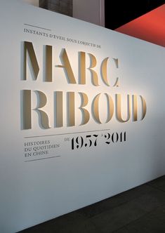 a large white sign that says marc ribboud in gold lettering on the wall