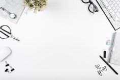 an overhead view of office supplies on a white desk