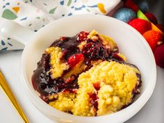 a bowl filled with fruit and ice cream next to a spoon on top of a table